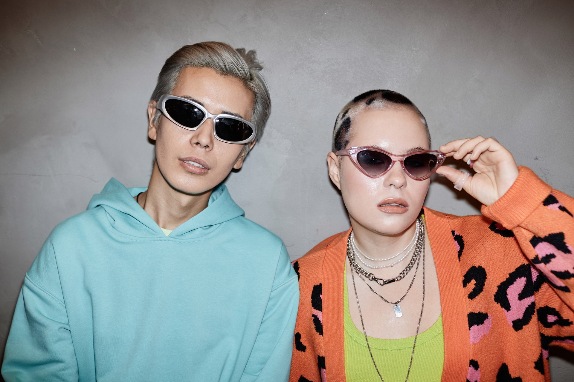Gen Z young couple wearing sunglasses and posing with flash