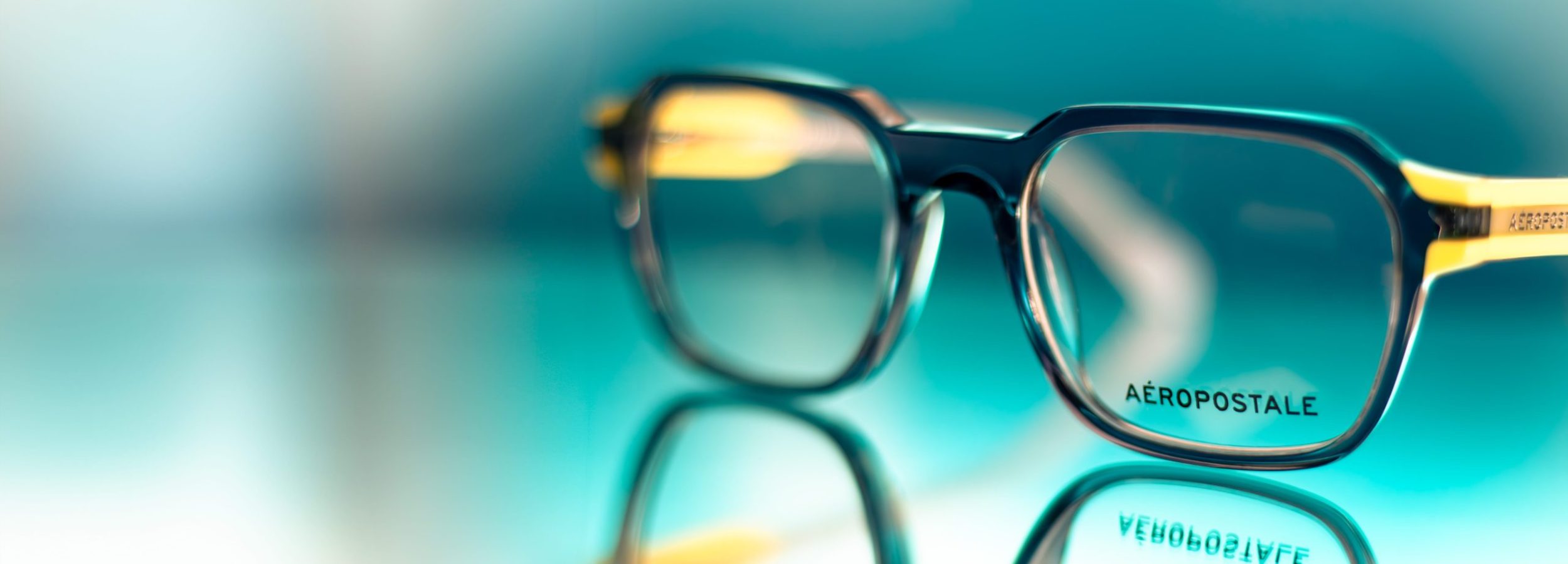 Yellow and blue men's Aéropostale frames on a reflective surface